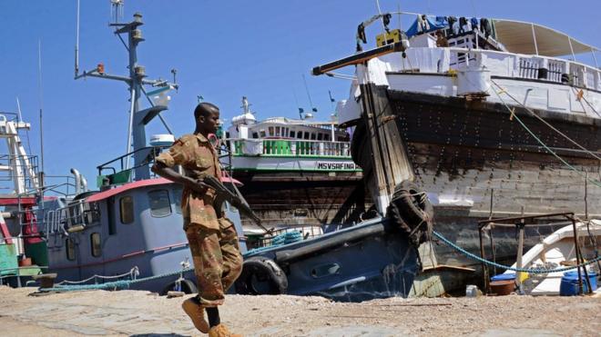 جندي صومالي يحمل السلاح في ميناء بوصاصو الصومالي