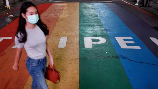 A pedestrian wearing a mask crosses the street in Taipei, Taiwan, 11 May 2021. Taiwan Health and Welfare Minister Chen Shih-chung announced during a press conference on 11 May, that Taiwan has entered the community transmission stage of COVID-19 following the emergence of six domestic cases of the disease that have unknown sources of infectio