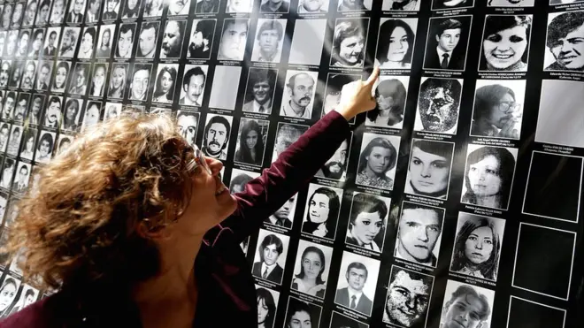 Josefina Giglio señala el retrato de su madre dentro de un cartel en el lugar donde estaba ubicado el centro de tortura El Atlético.