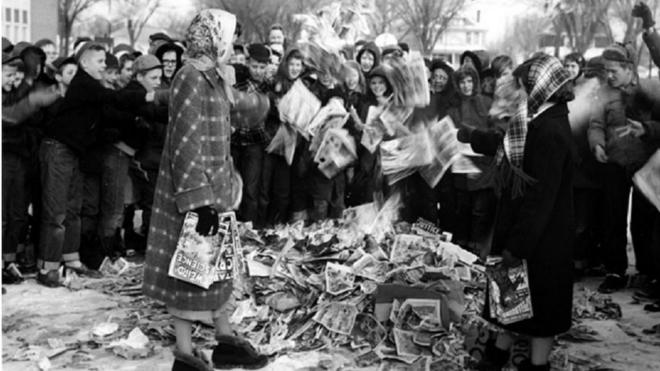 Crianças americanas ateiam fogo numa pilha de gibis, em foto de época