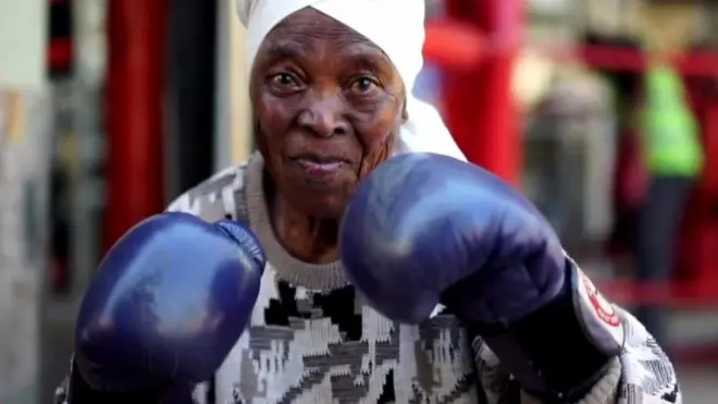 Zodwa Twala, 75 years old, raises her gloves