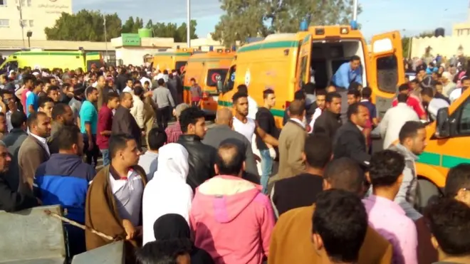 People gather around ambulances after the attack at the Rawda mosque on 24 November