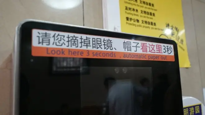 Chinese signs on the machines ask visitors to take off their glasses and hats before scanning