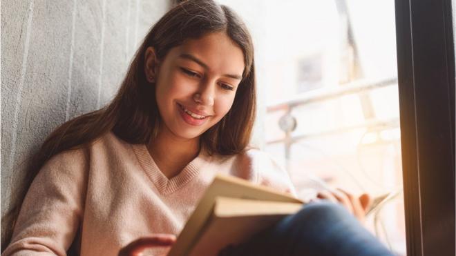 Una joven lee un libro.