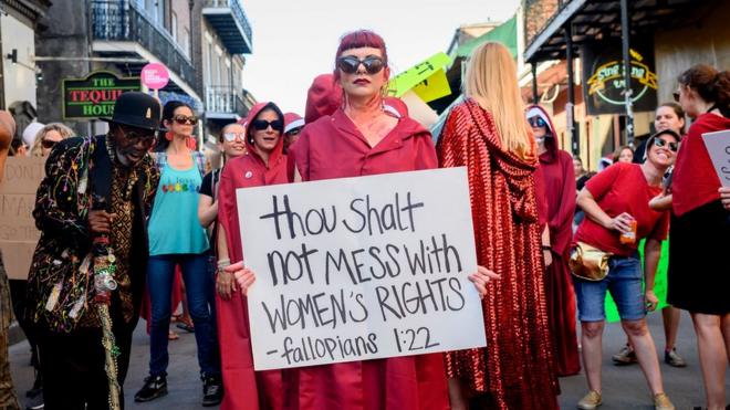 A protester holding a sign demanding protections for women's rights