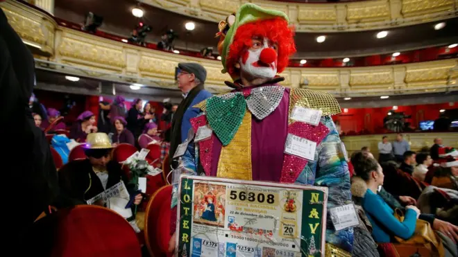 Un hombre disfrazado de payaso con fotocopias de su billete.