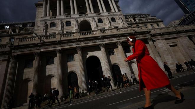 Woman walking past Bank of England