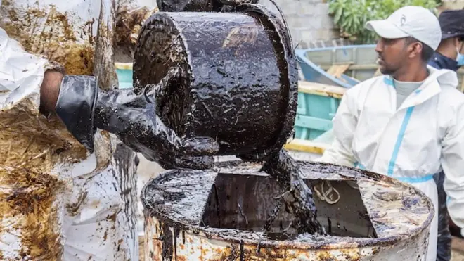 คนกำลังเทคราบน้ำมัน