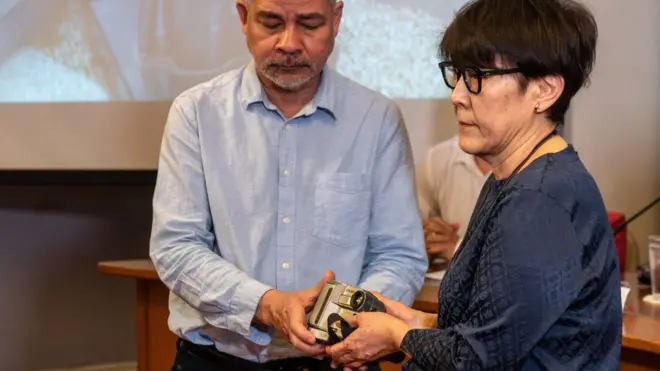 長井さんのカメラは妹の小川典子さん（右）に手渡された（26日、タイ・バンコク）