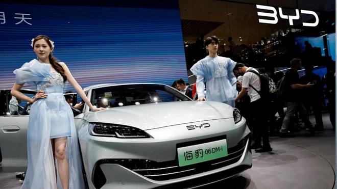 北京汽车展上两名模特正在展示比亚迪电动汽车