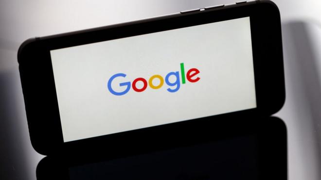 الصورة لجهاز آيفون يظهر على شاشته شعار شركة غوغل