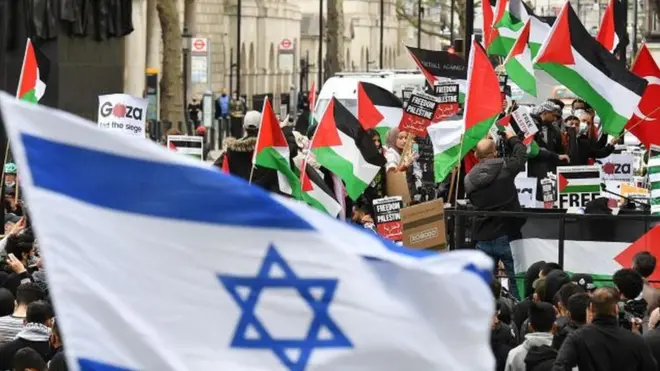 Una bandera israelí con banderas palestinas en el fondo, durante una manifestación en Londres, 11 mayo 2021