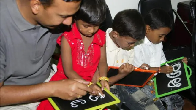 తెలుగు అక్షరాలు దిద్దుతున్న చిన్నారులు