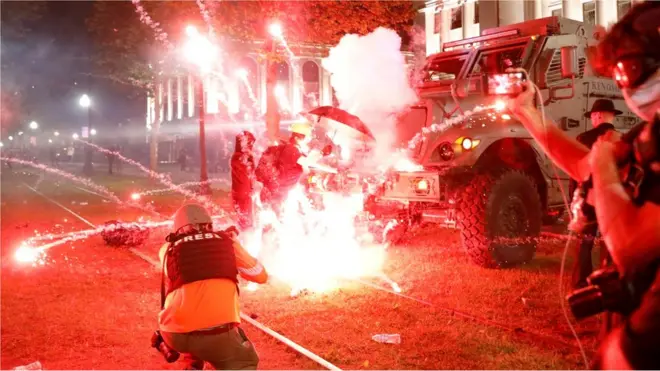 Flares go off in front of a Kenosha Country Sheriff Vehicle as demonstrators take part in a protest following the police shooting of Jacob Blake in Kenosha, Wisconsin, on 25 August 2020