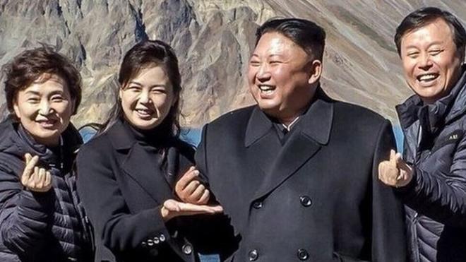 Los presidentes de Corea del Norte y Sur junto a otras personas forman un símbolo del corazón con los dedos.