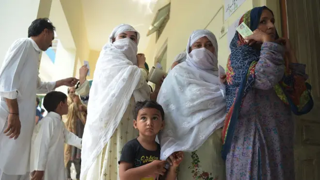 Women stand in a queue as they wait to cast their vote during Pakistan"s general election