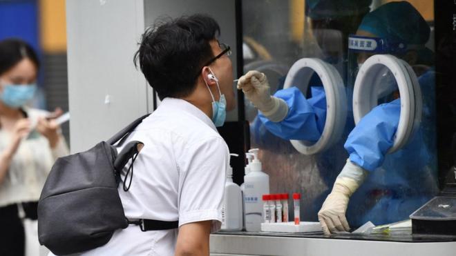 A health worker is tested for Covid-19 in Chengdu, China, on Thursday
