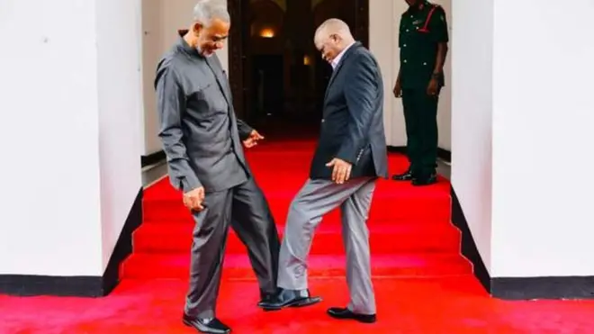 Perezida Magufuli (iburyo) asuhuzanya akoresheje ikirenge n'umunyapolitiki utavuga rumwe n'ubutegetsi