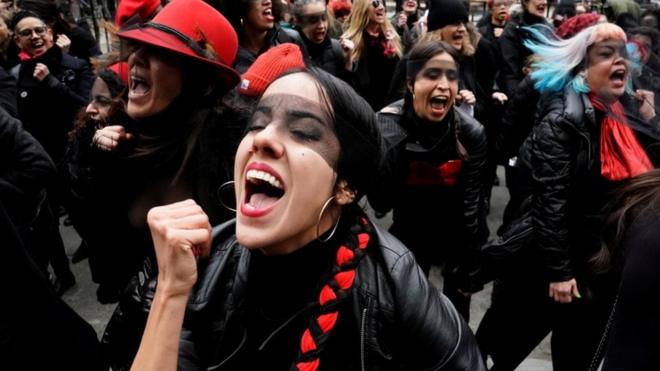 Women with blindfolds, pointing, during a protest performance on 10 January