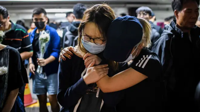 香港新界将军澳尚德邨多层停车场内两名悼念堕楼学生周梓乐的女士相拥而哭（8/11/2019）