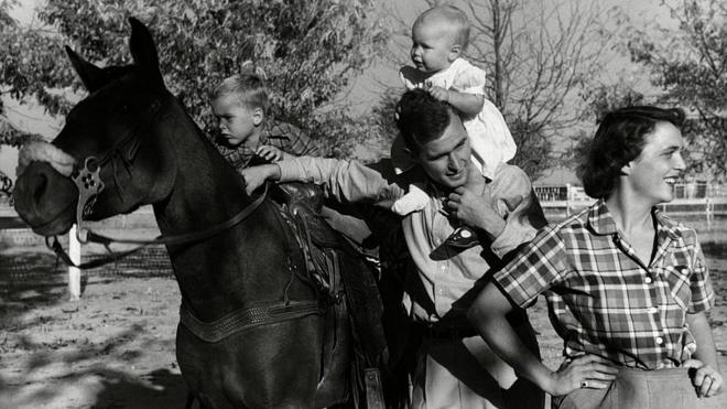 George H. W. Bush with his wife, Barbara, and their children Pauline and George W. on horse in the yard of their Midlands, Texas ranch