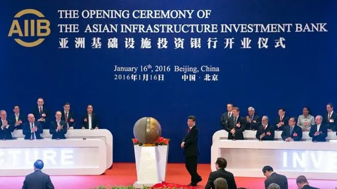 ผู้แทนของชาติที่ร่วมก่อตั้งธนาคารเพื่อการลงทุนในโครงสร้างพื้นฐานเอเชีย (AIIB) ปรบมือให้แก่ประธานาธิบดีสี จิ้นผิง ของจีน (กลาง) ขณะเปิดรูปปั้น ระหว่างพิธีเปิดธนาคารเอไอไอบีในกรุงปักกิ่ง เมื่อวันที่ 16 ม.ค. 2016