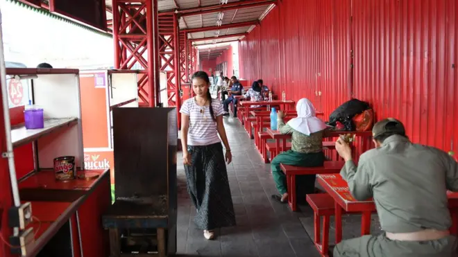 Pejalan kaki melintas di depan lapak pedagang binaan usaha mikro kecil dan menengah pusat kuliner Sumatera Barat di Jalan Kramat Raya, Jakarta.