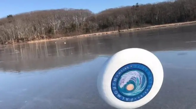 У США молодіжна команда з фризбі зафільмувала як вітер підхопив літаючий диск і покотив його крижаною поверхнею озера.