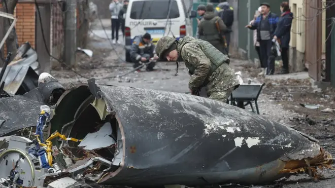 A solider inspects the remains of a plane shot down over the Ukrainian capital, Kiev