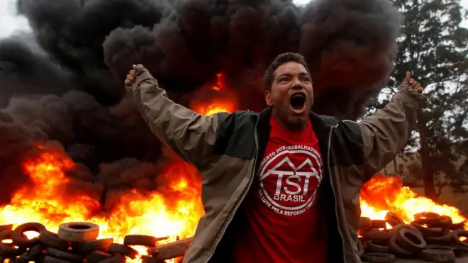 عضو في حركة العمال المشردين في البرازيل يرفع صوته احتجاجا على الرئيس البرازيلي، ميشيل تامر، في مدينة ساو باولو. ويطالب المحتجون باستقالة الرئيس وإجراء انتخابات جديدة وسحب الإصلاحات الاقتصادية. ويتعرض تامر لضغوط كبيرة بسبب مزاعم حول حصوله على رشى.