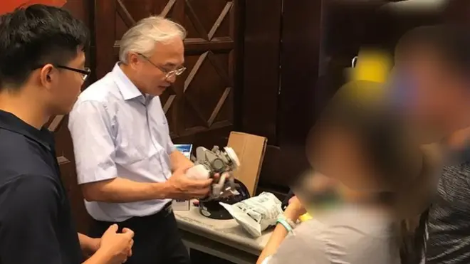 济南教会黄春生牧师，细心地解说每个防毒用具使用方式。