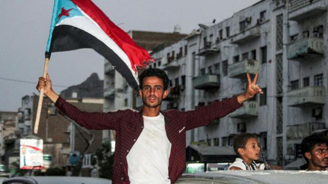 شاب يمني يرفع علم الجنوب