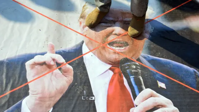 پاکستان کے زیرِ انتظام کشمیر میں ایک شخص امریکی صدر ڈونلڈ ٹرمپ کی تصویر پر کھڑا ہو کر احتجاج کر رہا ہے۔