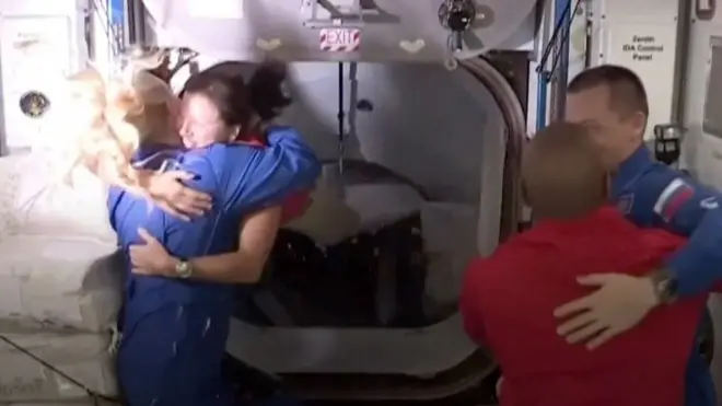 أربعة رواد فضاء يحضنون بعضهم البعض