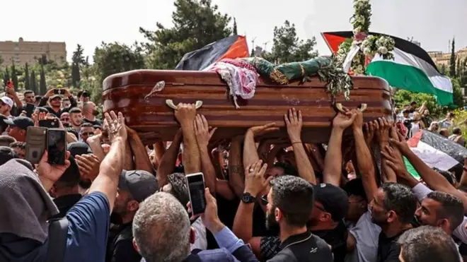 사람들이 기자의 관을 운구하고 있다