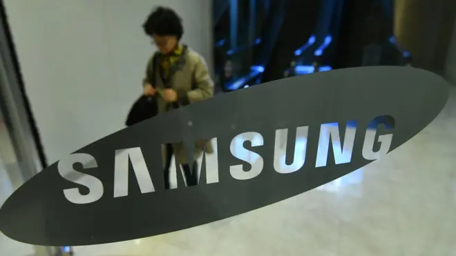 A woman walks past the logo of Samsung at the company's showroom in Seoul on October 31, 2018