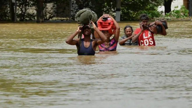Sri Lankan residents make their way through floodwaters in Kaduwela on May 27, 2017. Rainfall on May 26 triggered the worst flooding and landslides in 14 years in the southern and western parts of Sri Lanka, authorities said. The Disaster Management Centre (DMC) said 103 people were confirmed killed while another 113 were missing. / AFP PHOTO / ISHARA S. KODIKARA (Photo credit should read ISHARA S. KODIKARA/AFP/Getty Images)
