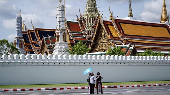 三名中国游客站在泰国曼谷大皇宫经典前景点前