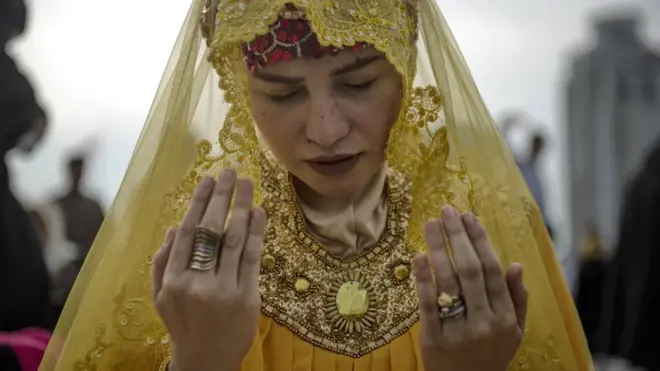 A Filipino woman attends prayers in a public park to celebrate Eid al-Fitr in Manila