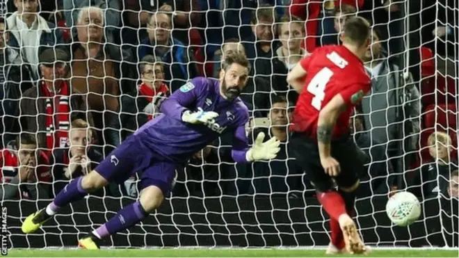 Kiper Scott Carson menahan tendangan bek Manchester United, Phil Jones, dan memastikan kemenangan Derby.