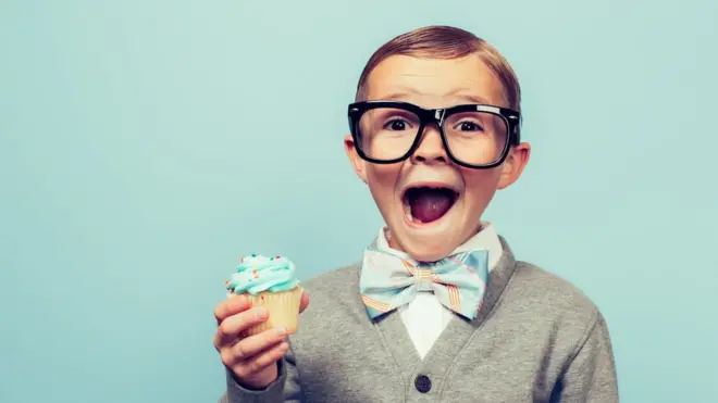 A stereotype of a geek, holding a cupcake