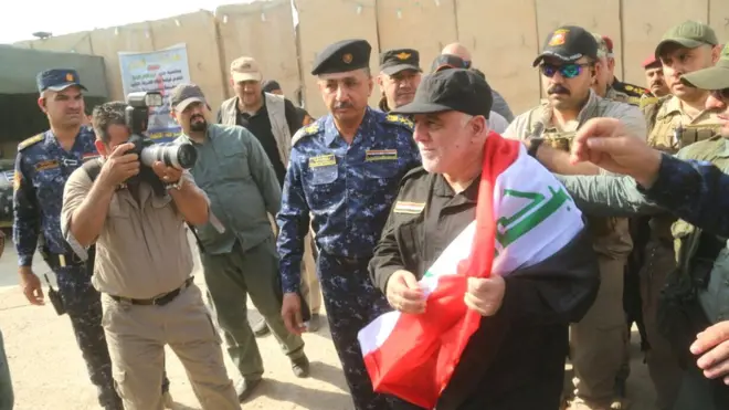 Perdana MenteriHaider al-Abadi mengenakan bendera Irak saat berkunjung ke Mosul.