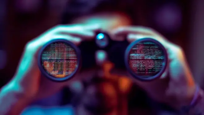 شخص ينظر من خلال منظار، تظهر على عدستيه رموز رقمية