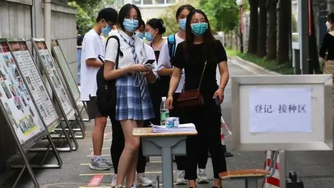 在中国南京，学生们排队接种新冠疫苗。
