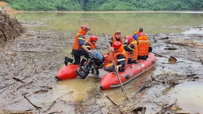 Một đội cứu hộ băng qua qua lòng hồ thủy điện Hương Điền tại xã Hương Bình, huyện Phong Điền, Huế, để tìm kiếm các nạn nhân mất tích trong vụ sạt lở đất tại khu thủy điện Rào Trăng 3.