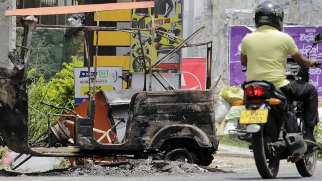 A Sri Lankan man rides his bicycle past a burnt vehicle a day after anti-muslim riots erupted in Digana, a suburb of Kandy on March 7, 2018. Sri Lanka on March 5 declared a nationwide state of emergency to quell anti-Muslim riots that have killed at least two people and damaged dozens of mosques and homes, a minister said. 'The cabinet of ministers decided on tough measures, including a 10-day nationwide state of emergency,' Minister of City Planning Rauff Hakeem said as police imposed a curfew in the riot-hit central district of Kandy. / AFP PHOTO / STR (Photo credit should read STR/AFP/Getty Images)