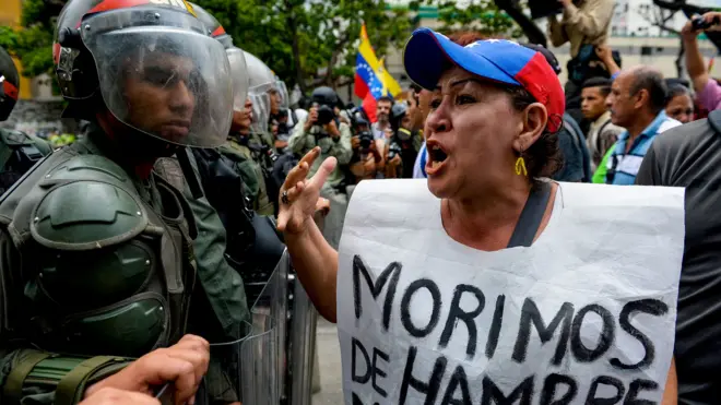 Kadın göstericinin önünde taşıdığı afişte 'Açlıktan ölüyoruz' yazıyor.