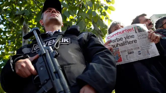Cumhuriyet gazetesine yönelik operasyonu protesto eden bir okuyucunun önündeki polis