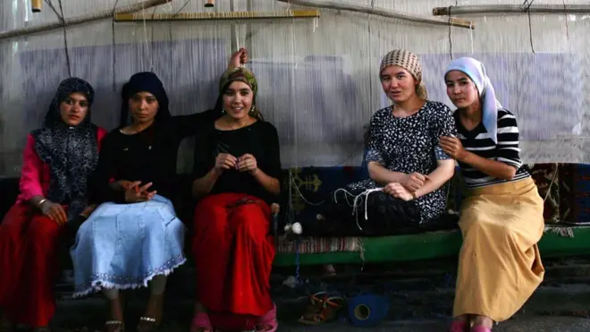 شابات أيغوريات مسلمات يعملن في معمل النسيج، في حتيان، شينغيانغ الملقبة منذ 3 آلاف عام بمدينة السجاد