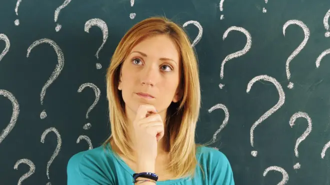 Una mujer pensando con signos de interrogación alrededor